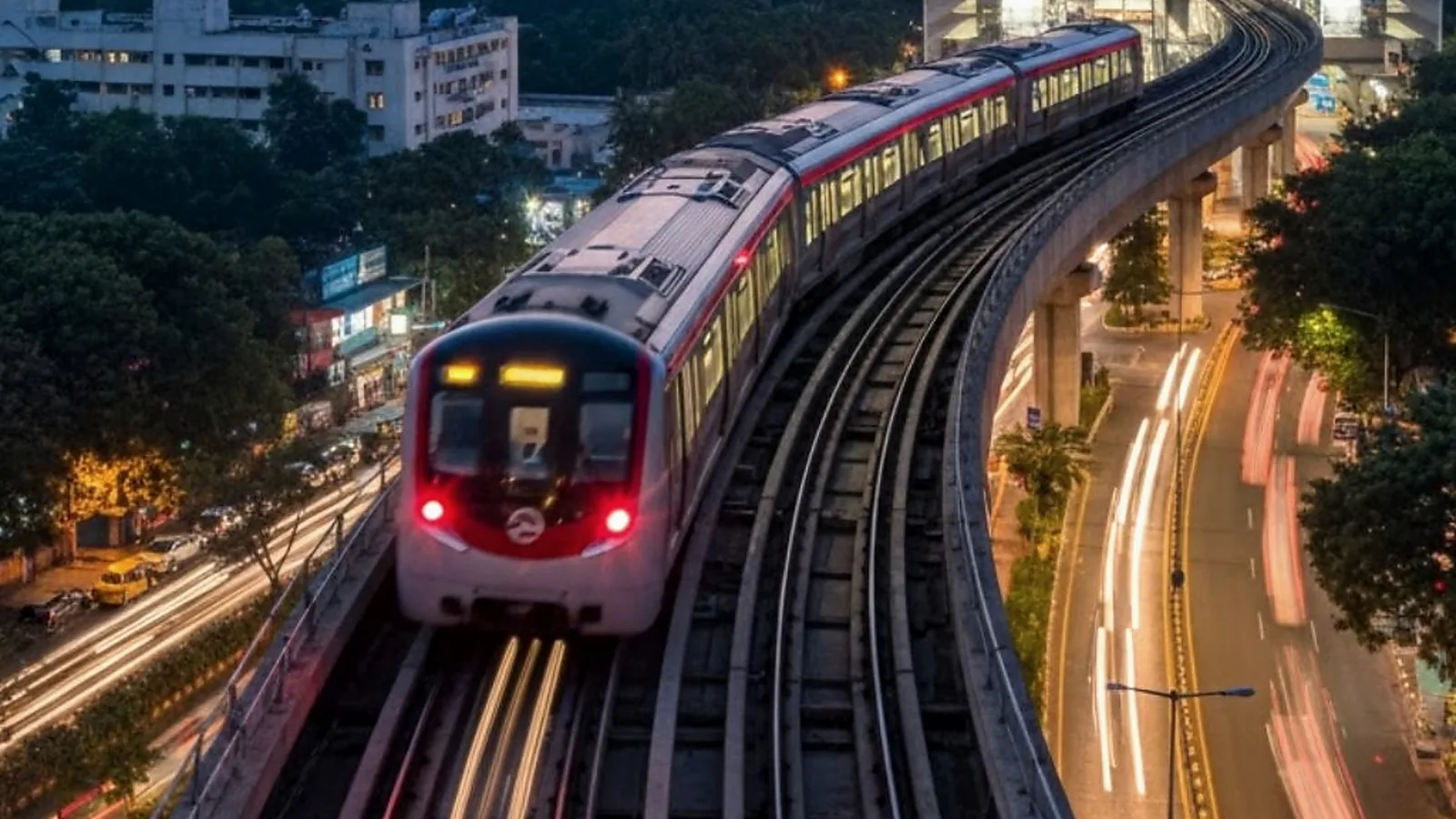 Metro rail approaching a curved elevated station at dusk, symbolic of the coming Sarjapur Metro Phase 3A